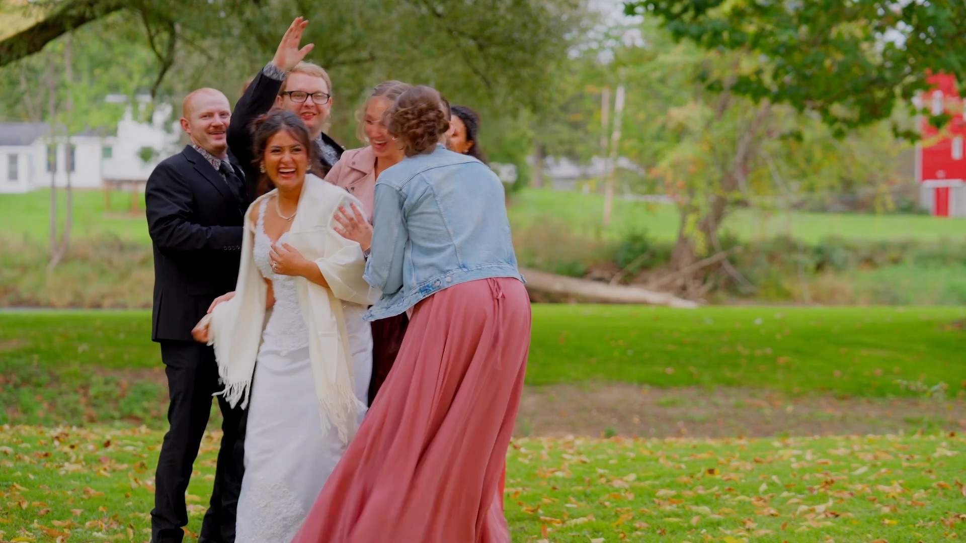 April laughing with her wedding party on the lawn